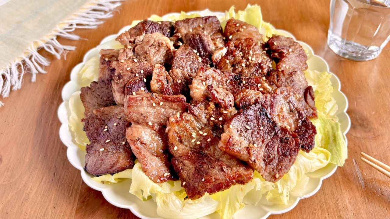 レタスを敷いた皿に盛りつけた牛肉の焦がしポン酢ペッパー焼き