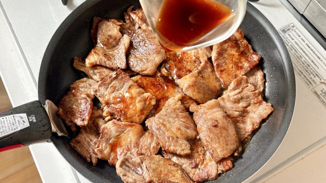 焼いた牛肉にポン酢しょうゆとにんにくのたれを加える工程