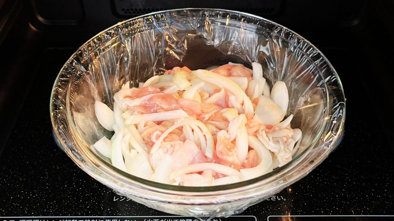 耐熱容器に入れた豚こま切れ肉と玉ねぎ