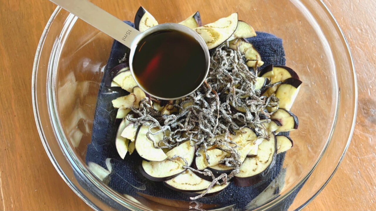 なすにポン酢とごま油を加える様子