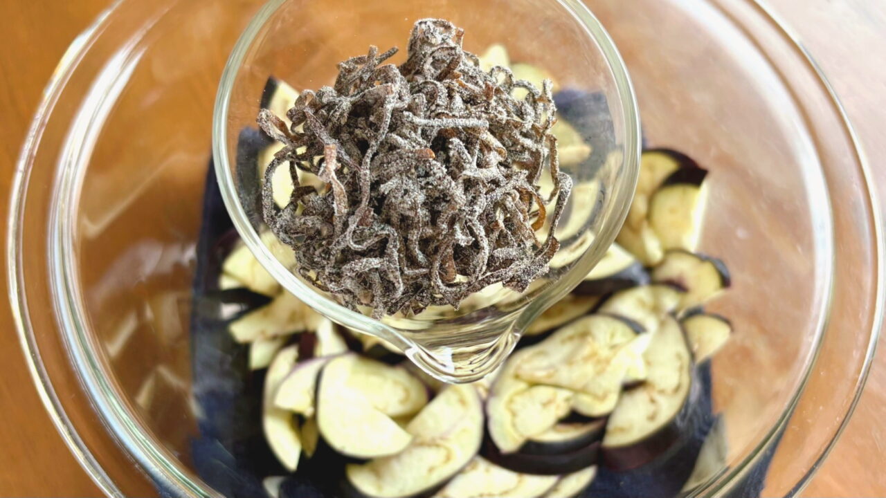 なすに塩昆布を加える様子