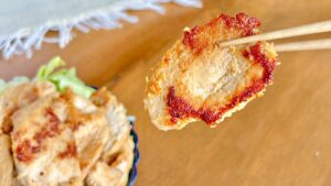 卵しょうゆ漬け焼きの鶏むね肉を箸で持ち上げたところ