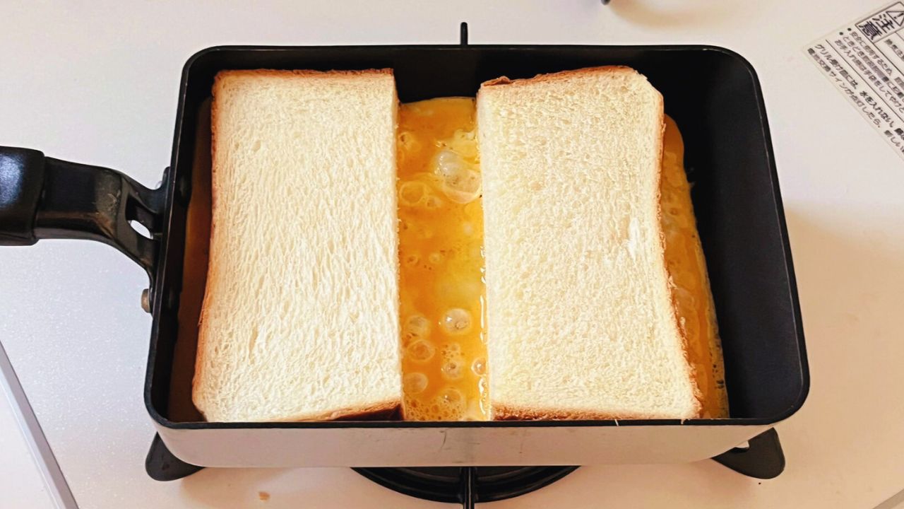 卵の上に半分に切った食パンを隙間をあけてのせた様子