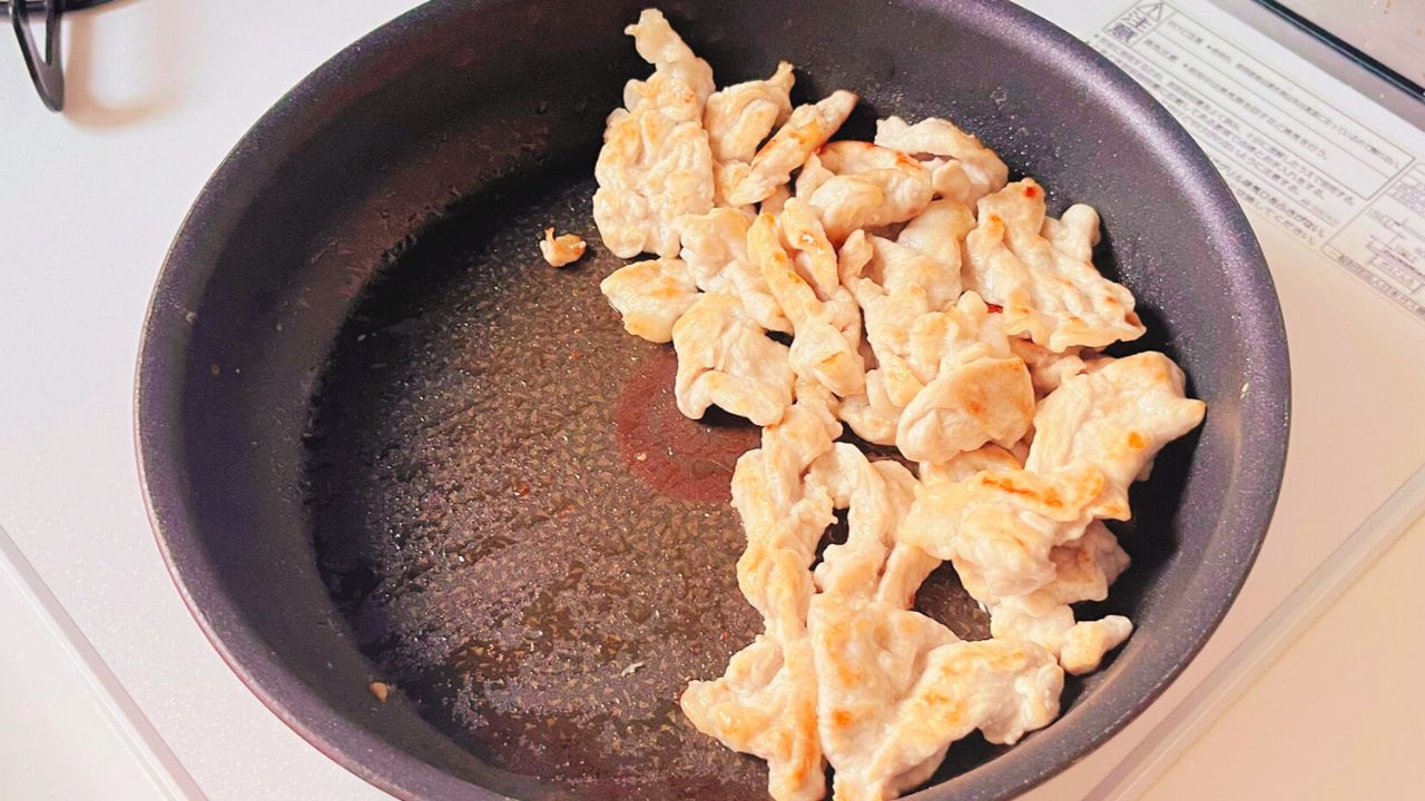焼き色をつけた豚こま切れ肉をフライパンの片側に寄せた様子