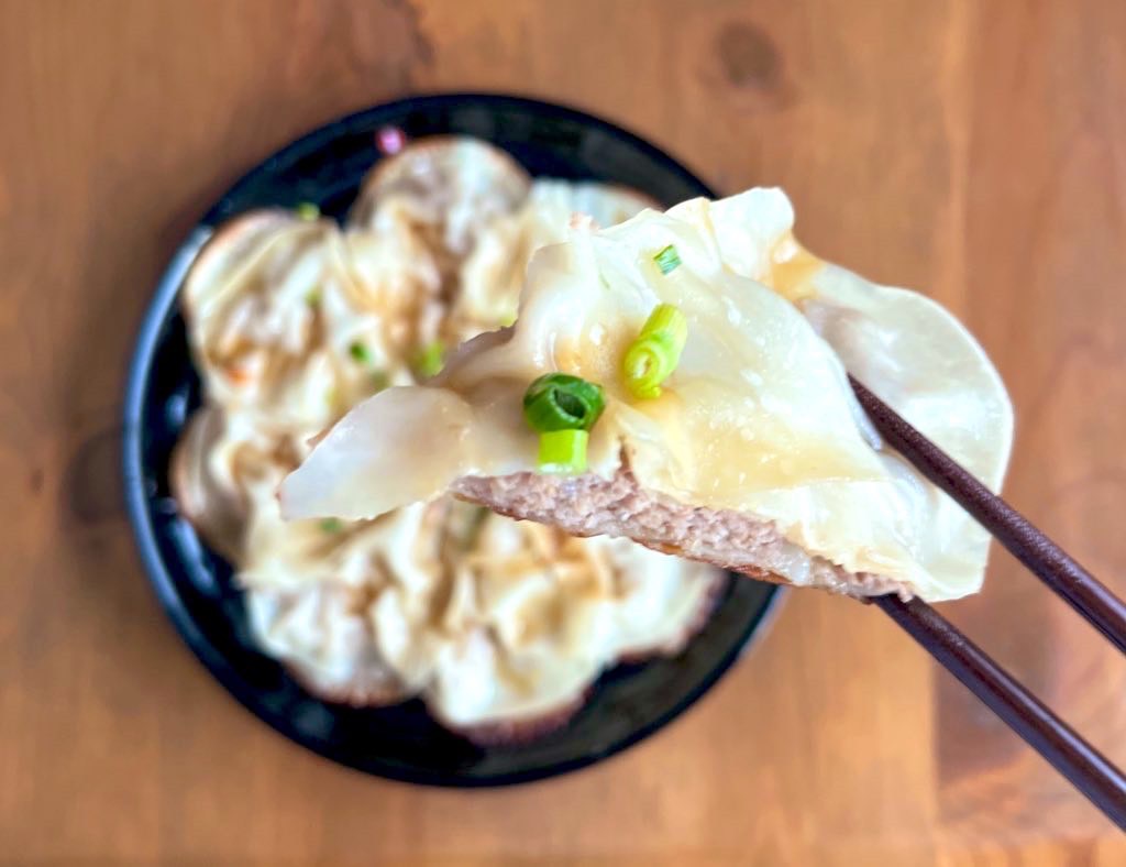 平たいギョーザを箸で持ち上げたところ
