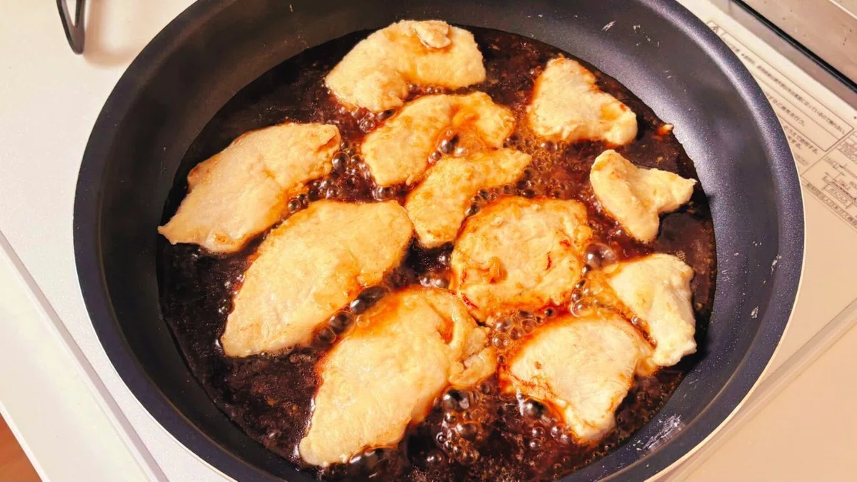 焼き面を入れ替えながらしょうがだれを煮からめる様子
