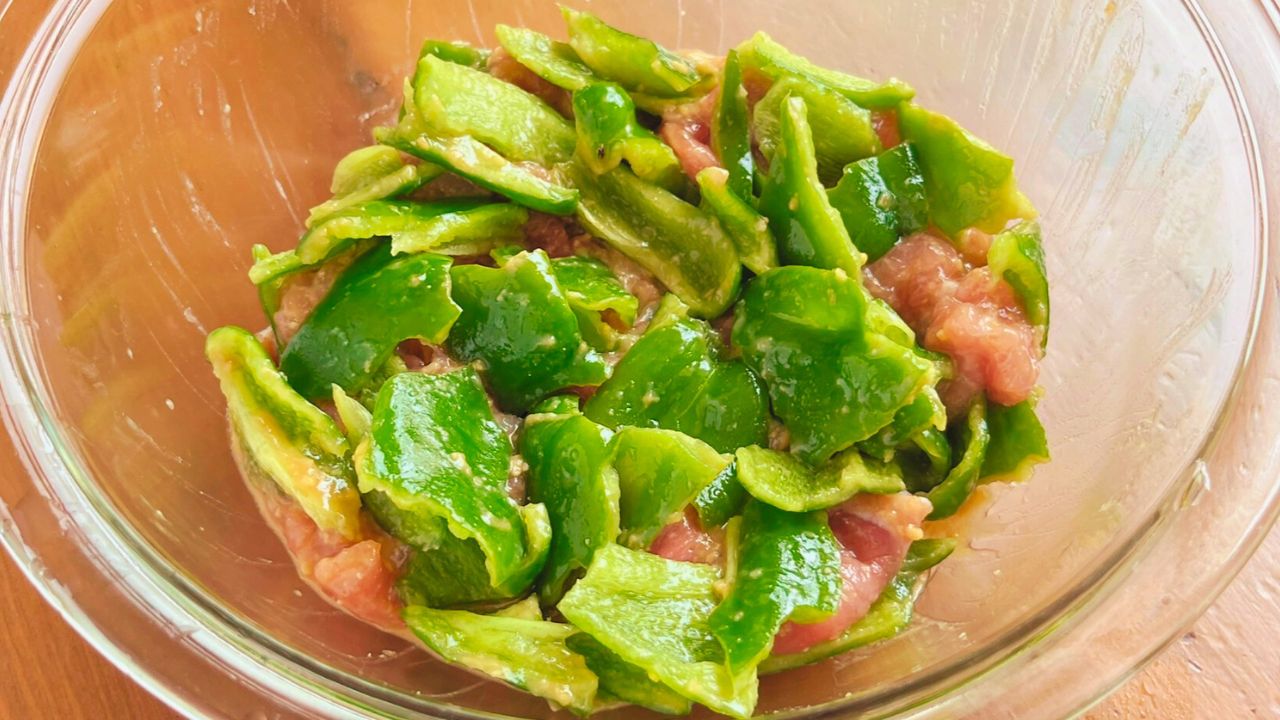 ちぎったピーマンと豚肉を混ぜた様子