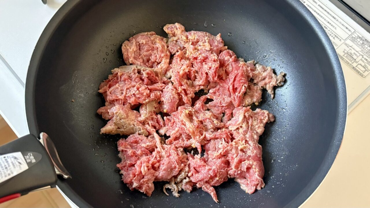 下味をつけた牛肉をフライパンで炒める
