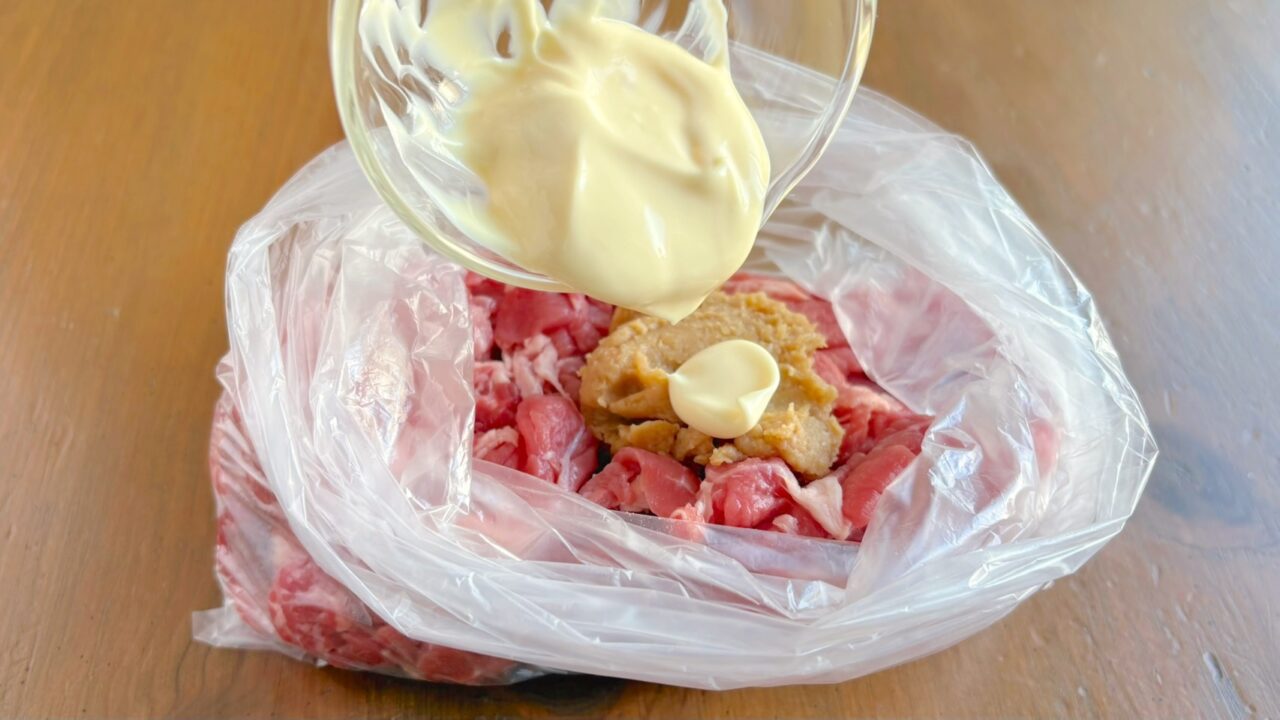 袋に入れた牛こま切れ肉に味噌とマヨネーズを加える