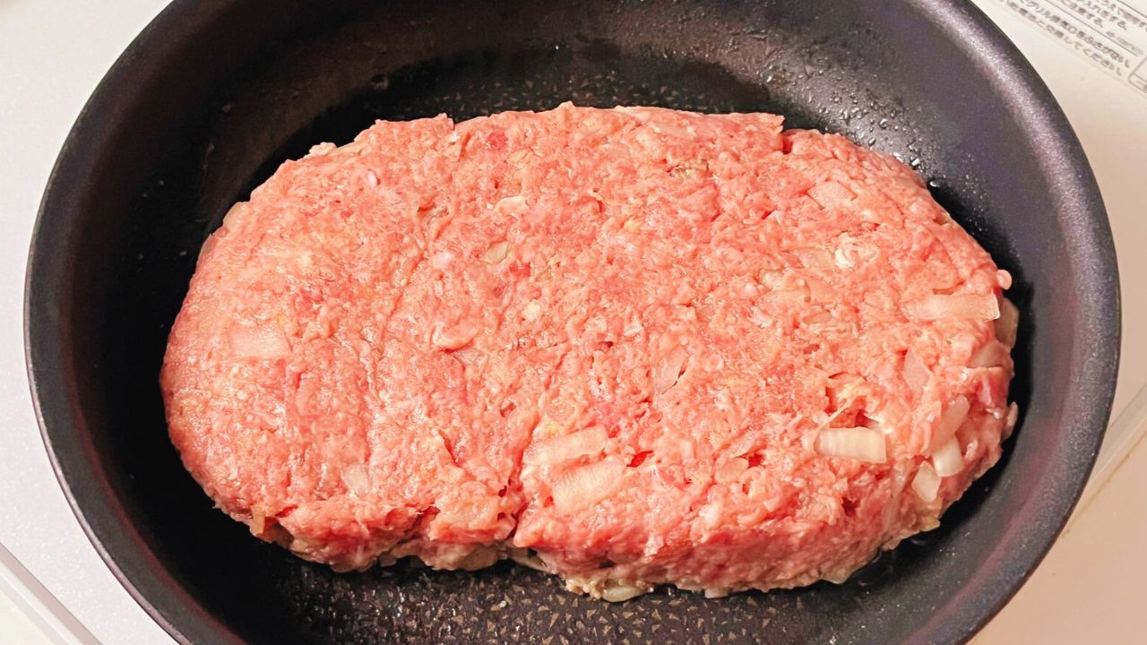 フライパンの上で大きな小判型に成形した肉だね
