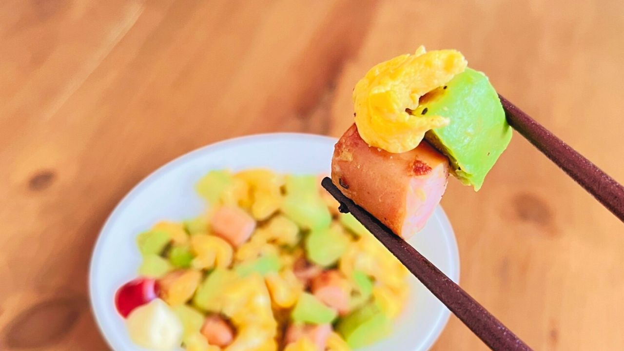 箸で持ち上げたアボカドとウインナーの卵炒め
