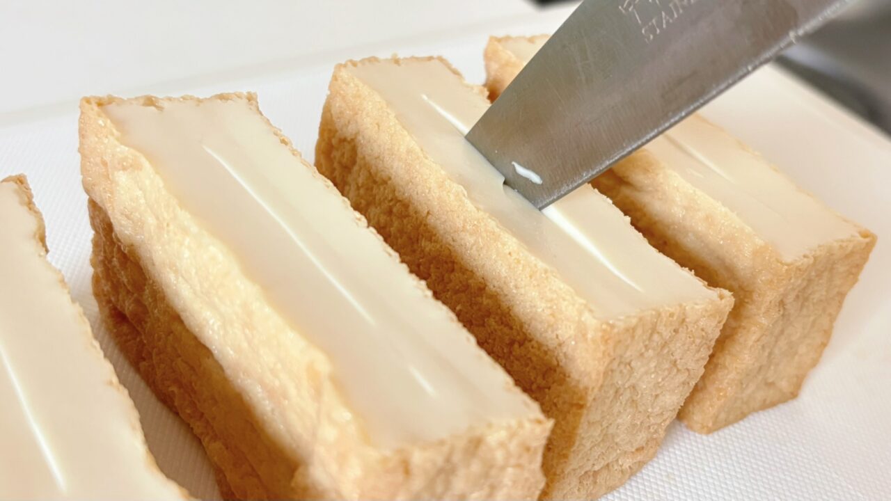 半分に切った厚揚げの断面へ切り込みを入れるところ