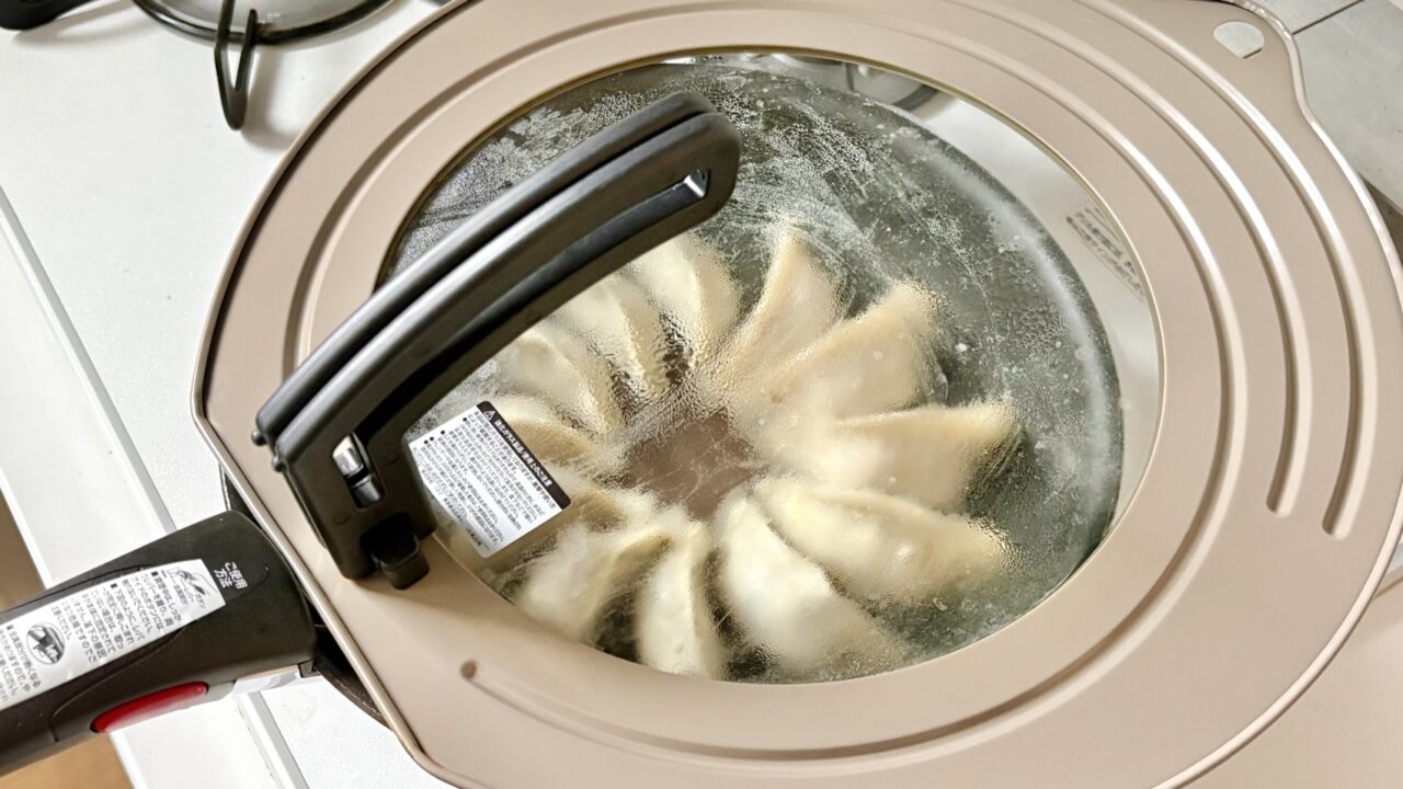 蓋をして餃子を蒸し焼きにしているところ