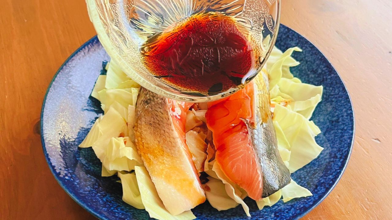 鮭とキャベツへ合わせ調味料を回しかけるところ