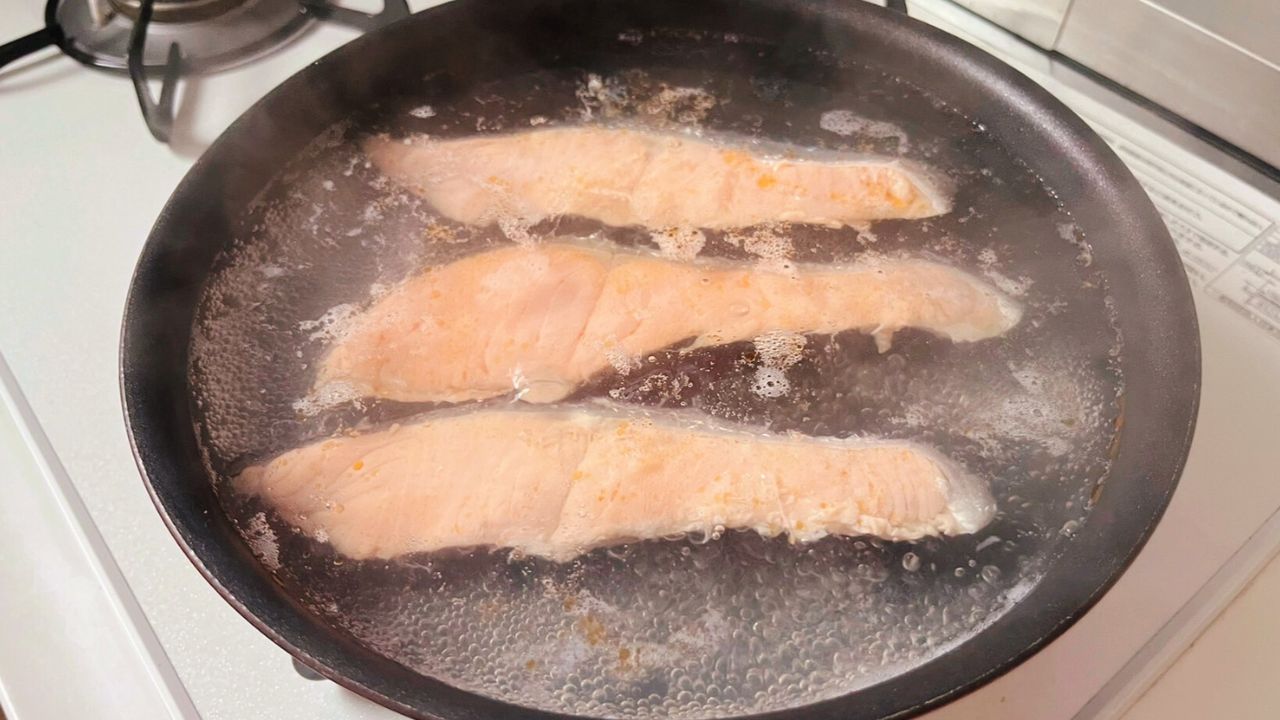 蓋をして塩鮭を茹でるところ